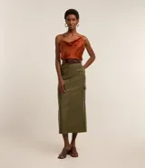 Falda midi color verde militar, confeccionada en cuero sintético, con bolsillos cargo laterales, abertura trasera y cierre frontal con botón y cremallera.