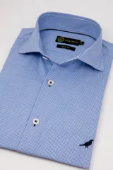 Camisa de manga larga Club House modelo Hudson, de corte slim fit con estampa de cuadros vichy en color celeste y blanco. Cuenta con cuello estructurado, botones blancos con costura en cruz y un pequeño bordado de un pájaro en la parte inferior.