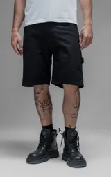 Bermuda de denim estilo carpintero con bolsillo lateral, confeccionada en algodón con efecto de desgaste y corte oversize.