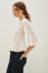 Camisa de algodón color negro, con cuello redondo, mangas tres cuartos abullonadas y detalles de encaje y alforzas en el frente y mangas.