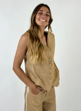Chaleco de lino con escote en V y cierre frontal con botones. Presenta un diseño entallado y sin mangas, ideal para un look sofisticado y fresco.