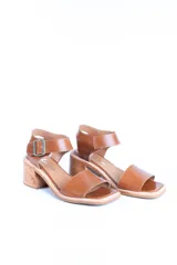 Sandalias de cuero color tostado con tira ancha sobre los dedos, tira al tobillo con hebilla y taco de madera.
