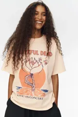 Remera oversized de punto de algodón color salmón, con hombros caídos, cuello redondo ribeteado y diseño estampado en el frente con la temática de Grateful Dead.
