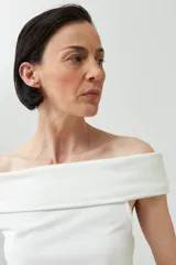 Remera de color marrón con escote bardot, diseño ajustado al cuerpo y mangas cortas.