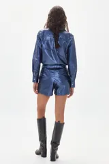 Short azul con textura brillante, tiro alto, pinzas delanteras y bolsillos laterales.