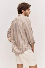 Camisa de manga larga de lino con diseño a rayas en tonos celestes y blancos, cuello camisero clásico y cierre frontal de botones.