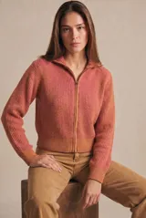 Campera tejida de algodón con diseño acanalado, cuello alto y cierre frontal completo. Presenta un patrón bicolor en tonos terracota y rosado, con puños y cintura elásticos.