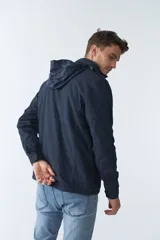 Campera de gabardina verde militar con capucha desmontable y ajustable, cierre frontal con cremallera y múltiples bolsillos con solapa.