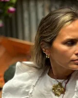 Collar con dije grande de bronce con forma orgánica y textura rugosa, suspendido de un cordón negro. Incluye cordones intercambiables.