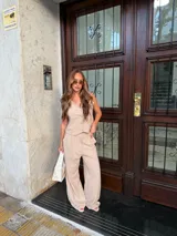 Chaleco de corte sastrero en tela tusor color beige con sutiles rayas verticales, escote en V y cierre frontal con botones al tono.