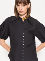 Camisa celeste de popelina, de silueta amplia y diseño liviano. Incluye cuello clásico y cierre frontal con botones.