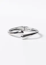 Brazalete rígido plateado de acero quirúrgico con diseño entrelazado y terminaciones redondeadas.