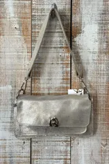 Cartera tipo mini bag con solapa, confeccionada en cuero con estampado animal print de leopardo. Cuenta con correa larga ajustable y cierre metálico frontal.