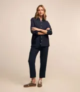 Camisa de manga larga color verde lima, con cuello camisero y botonadura frontal. Presenta un dobladillo trasero más largo que el delantero.