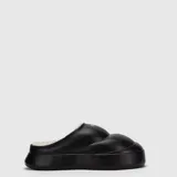 Pantuflas de diseño tipo mule con plataforma, confeccionadas en material sintético acolchado de color negro con interior de corderito sintético blanco.