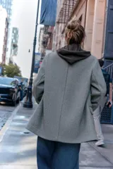 Blazer de corte recto y diseño minimalista, confeccionado en tejido de paño suave color beige. Presenta cuello con solapas clásicas, cierre frontal con un solo botón y dos bolsillos delanteros con solapa.
