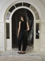 Musculosa entallada de tejido de punto con efecto lavado en tonos negro y gris, sin mangas y corte al cuerpo. Cuenta con un diseño de recortes estructurados y un estampado frontal en azul.