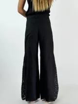 Pantalón de lino color beige, corte palazzo, con detalle de crochet en el lateral inferior.