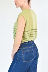 Musculosa de tejido de punto con diseño a rayas horizontales oscuras sobre base color crema, cuello redondo y corte recto.