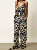 Pantalon tipo palazzo color negro con estampado paisley en tonos beige y blanco, corte holgado y tiro medio.