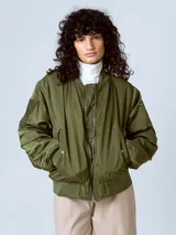 Campera estilo bomber acolchada, color verde militar, con hombros caídos y corte holgado. Presenta cierre frontal metálico y puños y cintura de elástico acanalado.