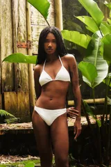 Conjunto de bikini blanco compuesto por un corpiño triangular con tiras para atar al cuello y a la espalda, y una bombacha clásica de tiro medio.