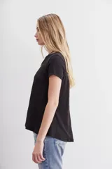 Remera básica de corte holgado, manga corta y cuello redondo, confeccionada en algodón peruano con textura jaspeada de color morado. Presenta un diseño de largo irregular con ruedo redondeado.