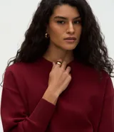 Buzo de tricot con cuello redondo y puños ajustados. Presenta un diseño de calce holgado y tejido de punto liso.