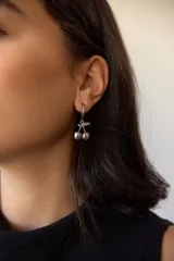 Aros de acero quirúrgico hipoalergénico, con argolla pequeña y dije colgante en forma de cerezas.
