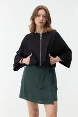 Campera negra corta con cierre frontal y mangas anchas.