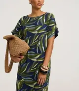 Vestido midi de corte recto y cuello redondo, confeccionado en viscolycra con estampa de follaje en tonos verdes y azules. Presenta mangas cortas con recortes y aberturas laterales en el ruedo.