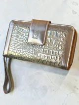 Billetera grande de cuero con acabado metalizado dorado y textura tipo reptil. Cuenta con un compartimento frontal con solapa y cierre a presión, decorado con el logo de la marca grabado.