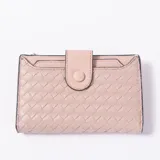 Billetera Aelvira de cuero sintético color rosado, con diseño trenzado y cierre de solapa con broche a presión.