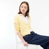Chaqueta de punto con textura de croché en color amarillo pastel, con diseño de cuello en V, cierre frontal con lazada y terminaciones festoneadas en mangas y ruedo.