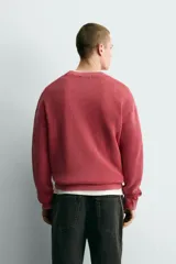 Sweater relaxed fit de canalé, color negro con efecto lavado, cuello redondo y manga larga con acabados en rib.