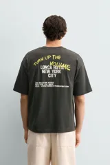 Camiseta de algodón con corte relajado, cuello redondo y manga corta. Presenta estampados gráficos a contraste en el frente con inscripciones tipo señalética.