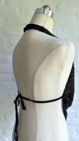 Top negro con lentejuelas, escote drapeado y tiras finas que se atan en la nuca y en la espalda.