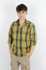 Camisa de manga larga de algodón 100%, con cuello italiano y estampado a cuadros en tonos verde oliva y azul marino. Cuenta con cierre frontal de botones y un pequeño bordado en el pecho.