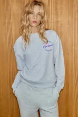 Sudadera de cuello redondo y manga larga, confeccionada en tejido gris melange. Presenta un diseño estampado en el pecho con un corazón y la frase 'Pasta fresca Ciao cara! Dell'Italia'. Cuenta con puños y ruedo acanalados.
