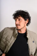 Campera puffer de corte clásico en color beige, con cierre frontal, cuello alto y puños elásticos. Presenta un diseño acolchado horizontal y un pequeño logo bordado en el pecho.