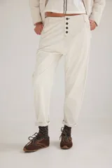 Pantalón de pana de algodón con tiro bajo y calce relajado. Presenta una botonadura frontal visible como detalle principal y diseño de estilo vintage.