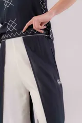 Pantalón de viscosa azul marino con cruce en las piernas tipo pareo, generando tajos laterales. Presenta bordados blancos en los bordes.