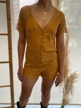 Mono corto color ocre con encaje floral, escote en V y mangas cortas.