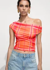 Top corto de escote barco con diseño de hombros descubiertos, confeccionado en tejido elástico con estampado de cuadros en tonos naranja y fucsia.