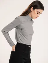 Polera gris de rib elastizado con brillos, cuello alto y mangas largas.