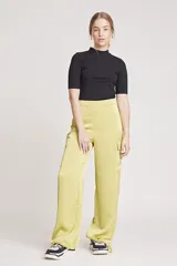 Pantalón de vestir color verde oliva, de corte ancho y tiro alto, con bolsillos laterales tipo cargo y detalle de pinzas en la cintura.