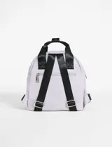 Mochila color tostado con textura símil cuero, bolsillo frontal con cierre, asa corta superior y tiras traseras regulables.