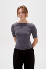 Remera de poliamida color blanco, de corte ajustado al cuerpo, con mangas 3/4 y cuello redondo a la base.