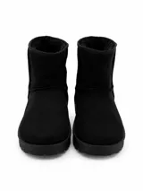 Bota de caña media color negro, confeccionada en material tipo gamuza con interior forrado en piel sintética y suela de goma con plataforma dentada.