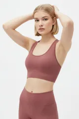 Top deportivo negro de tejido acanalado, con escote redondo y diseño ajustado al cuerpo.